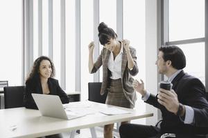 sorridente imprenditrice sorridente celebrare il successo o il successo con il collega in ufficio moderno foto