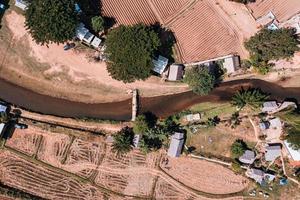 villaggio agricolo con fiume attraverso e campo arido in estate in campagna foto