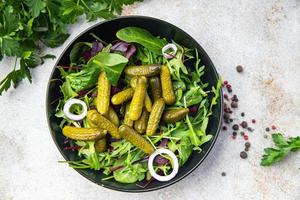 insalata cetriolini cetrioli sottaceto foglie verdi salate mix vegano o vegetariano foto