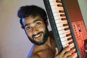 uomo con pianoforte elettronico e sorridente foto