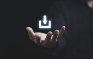 mano che tiene il simbolo del segno di download virtuale per la trasformazione della tecnologia e il concetto di condivisione. foto