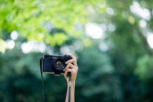 fotografo e amante della fotocamera fotocamera nera e sfondo verde naturale foto