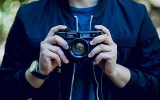 la mano e la fotocamera del fotografo viaggiano in montagna e fotografano il concetto di natura foto