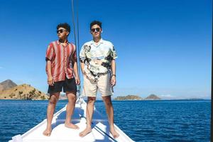 due uomini asiatici in occhiali da sole in piedi su una barca phinisi foto
