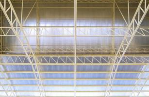 vista ad angolo basso della struttura del tetto in metallo con isolamenti termici all'interno di un cantiere edile industriale foto