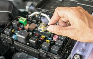 meccanico che controlla un fusibile dell'automobile foto