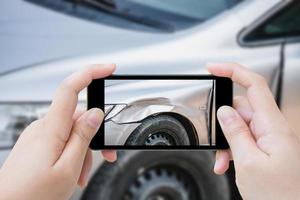 donna che utilizza lo smartphone mobile scatta una foto incidente d'auto