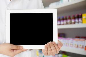 farmacista che mostra tablet computer in farmacia foto