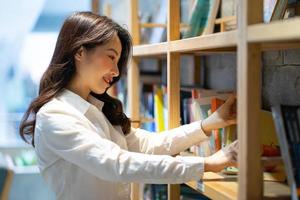 immagine del libro di lettura asiatico della donna di affari in biblioteca foto