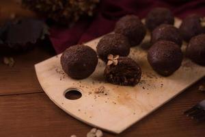 palline di cacao, torte al tartufo di cioccolato a bordo su fondo di legno foto