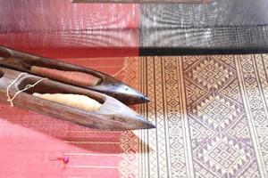 bobine per tessitura utilizzate con piccoli telai in legno per la tessitura nelle famiglie thailandesi rurali. foto