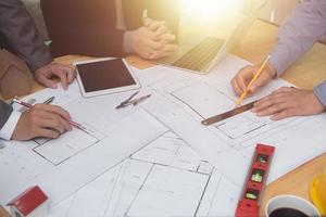 team di architetti o ingegneri che discutono sulla scrivania con un progetto sul nuovo progetto di avvio sulla scrivania. gruppo di squadra sui documenti di controllo del sito di costruzione e sul flusso di lavoro aziendale. messa a fuoco selettiva. foto