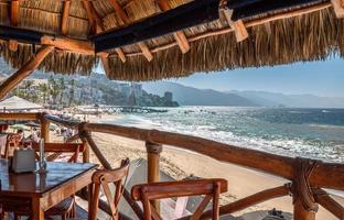 ristoranti e caffè con vista sull'oceano sulla spiaggia e sul molo di playa de los muertos vicino alla famosa puerto vallarta malecon, la spiaggia pubblica più grande della città foto