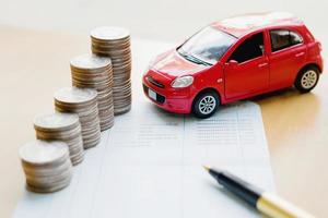 denaro, pila di monete con libro di risparmio e auto, concetto foto