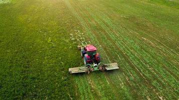 un trattore falcia un campo di fotografia aerea con drone foto