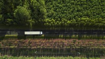 camion che guida lungo una strada forestale vista aerea da un drone foto