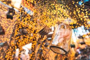 bottiglia di vetro decorativa in aria con sfondo bokeh dorato brillante foto