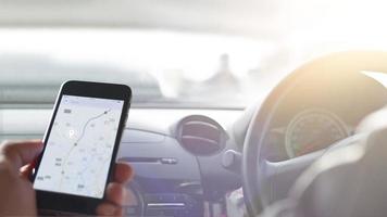 mano utilizzando la navigazione gps dello smartphone all'interno dell'auto foto