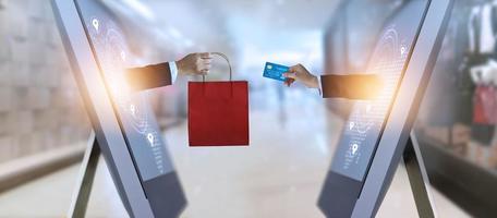 e-commerce, borsa della spesa con mano e carta di credito dallo schermo e concetto online di rete globale, shopping e pagamenti foto