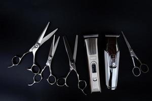 un set di strumenti per tagliare i capelli su sfondo nero per il taglio del salone della barba da barbiere foto