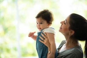 la giovane madre e il bambino sono felici a casa, concetto di famiglia d'infanzia con mamma caucasica e bambino, stile di vita per la cura del neonato foto