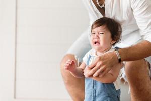 bambino bambino piccolo persona piange a casa, i neonati piangono e vivono al chiuso una casa con la famiglia, concetto di cura dell'infanzia e confortante foto