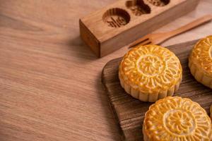 Torta lunare a forma rotonda mooncake - pasticceria tradizionale in stile cinese durante il festival di metà autunno festival della luna su sfondo di legno e vassoio, primo piano foto