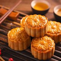 Moon cake mooncake table setting - pasticceria tradizionale cinese di forma rotonda con tazze da tè su sfondo di legno, concetto di festival di metà autunno, primo piano. foto