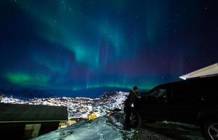 bella aurola luce del nord sopra il paesaggio urbano della città. aurora boreale nel sud di kitaa qaqortoq Groenlandia foto