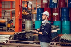 responsabile tecnico dell'operaio di fabbrica intelligente che lavora in un cantiere industriale, indossando un elmetto per la sicurezza foto