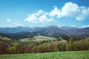 paesaggio della collina con covoni di fieno nelle grandi montagne in primavera nella giornata nuvolosa foto