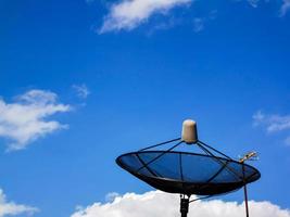 un'immagine di un cielo nuvoloso diurno e una parabola satellitare della TV di casa. foto