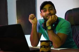 ragazzo indiano sorridente con un computer portatile che lavora o studia online foto