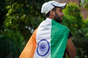 l'uomo indiano avvolge la bandiera indiana, l'uomo che mostra amore alla bandiera indiana foto