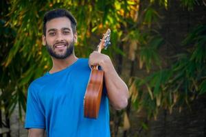 ragazzo con ukulele uno strumento musicale immagine bella musicista indiano foto