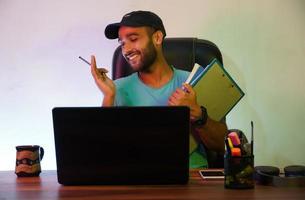 uno studente sorridente e seduto con il laptop foto