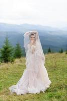 la sposa in un vestito rosa arioso volteggia e gioca con il suo vestito. foto