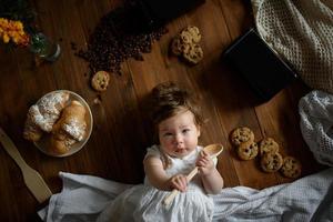 la bambina cuoca con un cucchiaio di legno sta preparando il pranzo. foto