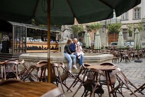 i genitori e la figlia sono seduti sui gradini di una vecchia chiesa. foto