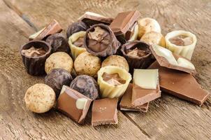 cioccolatini e cioccolato in un cestino su un tavolo di legno foto
