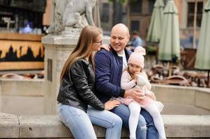 i genitori e la figlia sono seduti sui gradini di una vecchia chiesa. foto