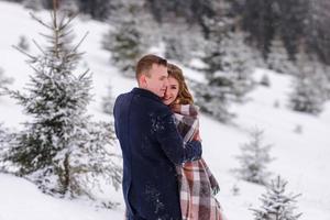 lo sposo conduce la sua sposa per mano a un vecchio faggio solitario. matrimonio invernale. posto per un logo. foto