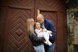 i genitori e la figlia sono seduti sui gradini di una vecchia chiesa. foto