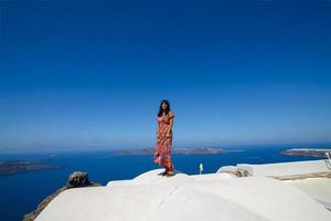 un uomo e una donna si abbracciano sullo sfondo della roccia di skaros sull'isola di santorini. il paese di imerovigli. foto