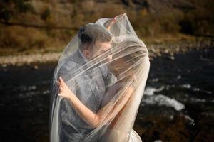 la giovane bella sposa si rifugia sotto una foto. la retroilluminazione brillante risplende nella cornice foto