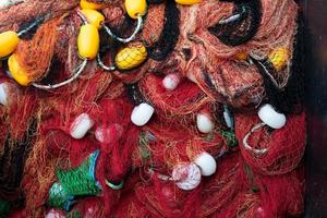 reti da pesca impilate e corde rosse, verdi, blu e bianche foto