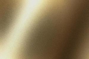 sfondo texture astratta, luce che brilla sul metallo dorato in una stanza buia foto