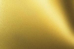 luce che brilla su una lastra metallica dorata in una stanza buia, sfondo a trama astratta foto