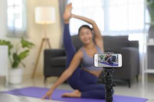 allenatore di yoga professionale che insegna lezioni di formazione online agli studenti durante lo streaming live sui social media, concetto di assistenza sanitaria foto