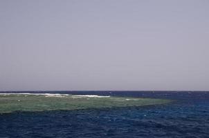 scogliera con acqua di mare blu foto